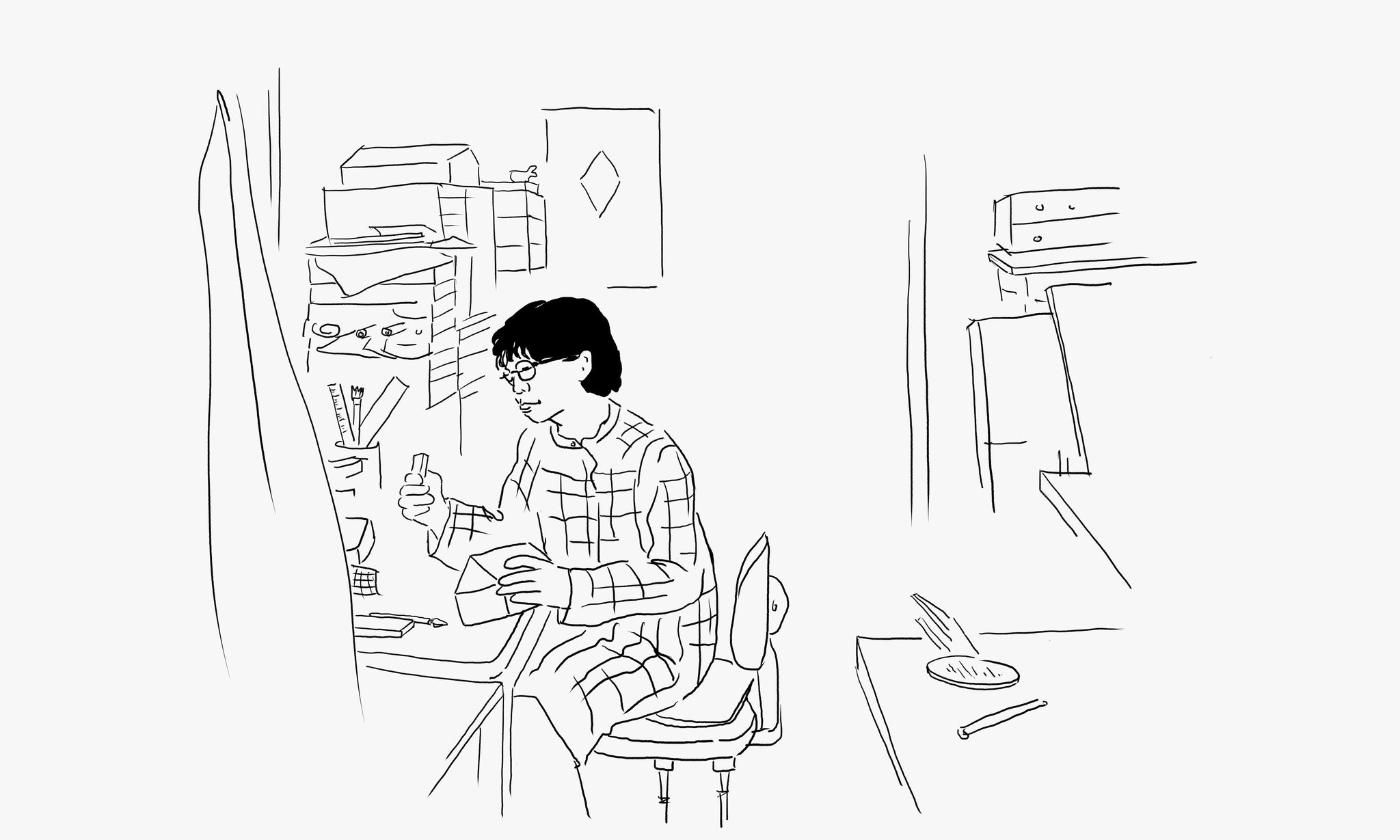 Black and white line drawn illustration of Michiko Iwata at a desk in her studio
