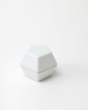 White geometric spice mill on a light gray background
