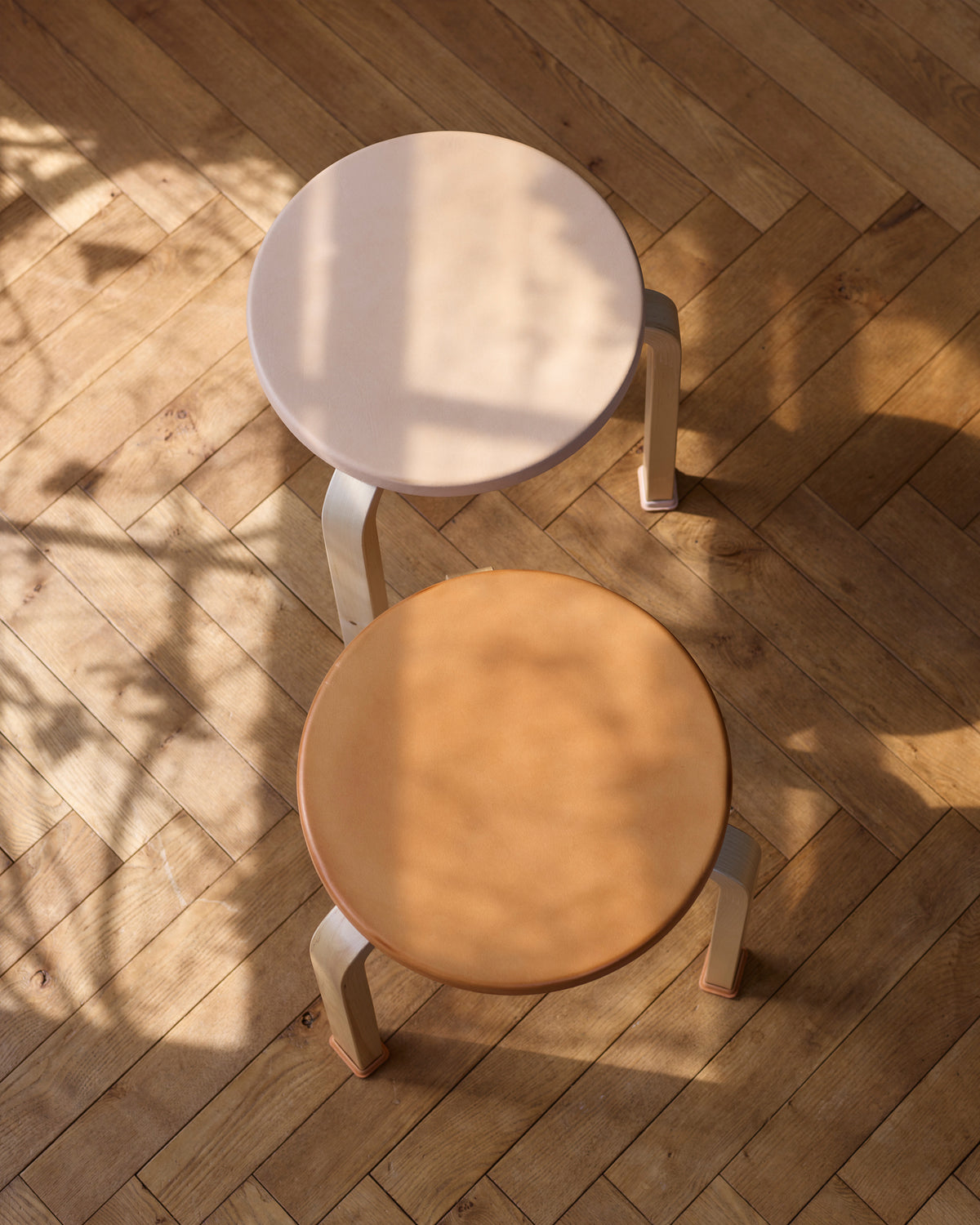 Up-side view of new and aged stool with shoes by Artek and Hender Scheme