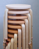 Stacked stool with shoes by Artek and Hender Scheme on a white background