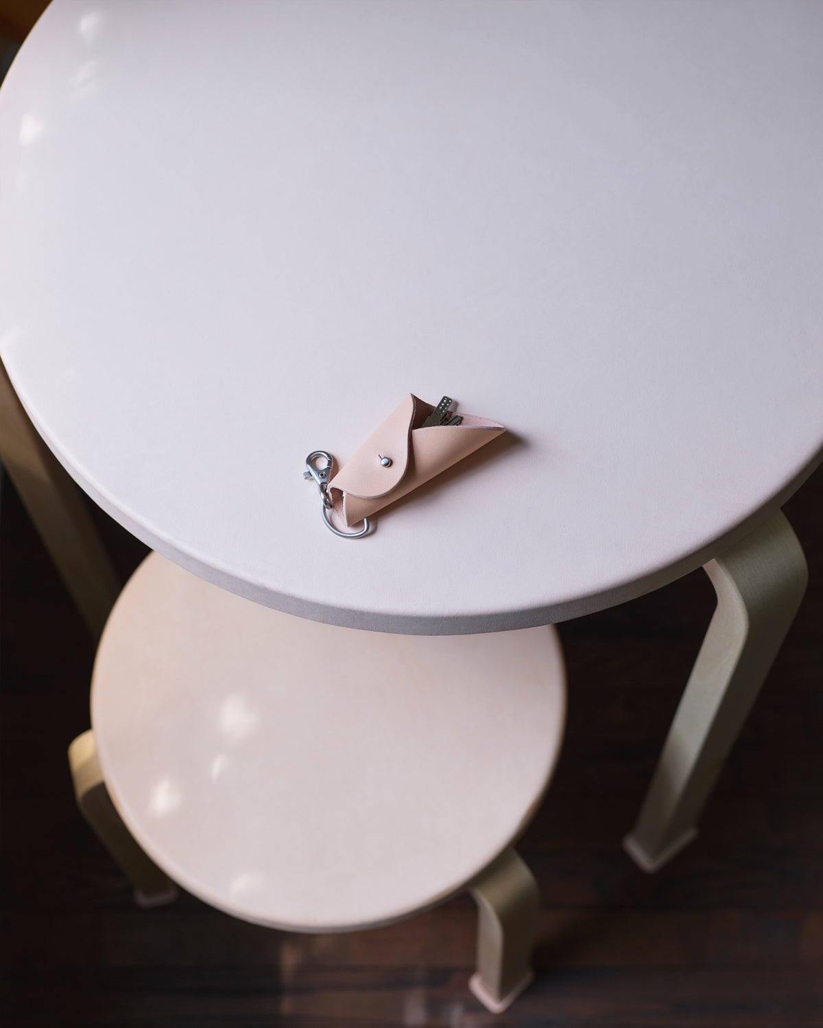 Leather table and stool with shoes with a key chain by Hender Scheme and Artek 
