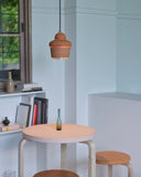 Leather table, stools, pendant light by Hender Scheme and Artek in a room with a bookshelf in the background