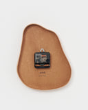 Back side of leather Clock by Hender Scheme on a gray background