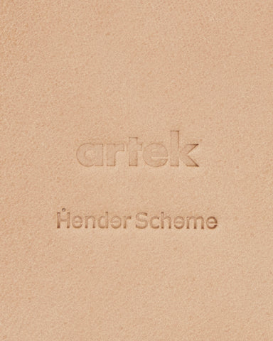 Up-close of Coaster by Hender Scheme and Artek on a gray background