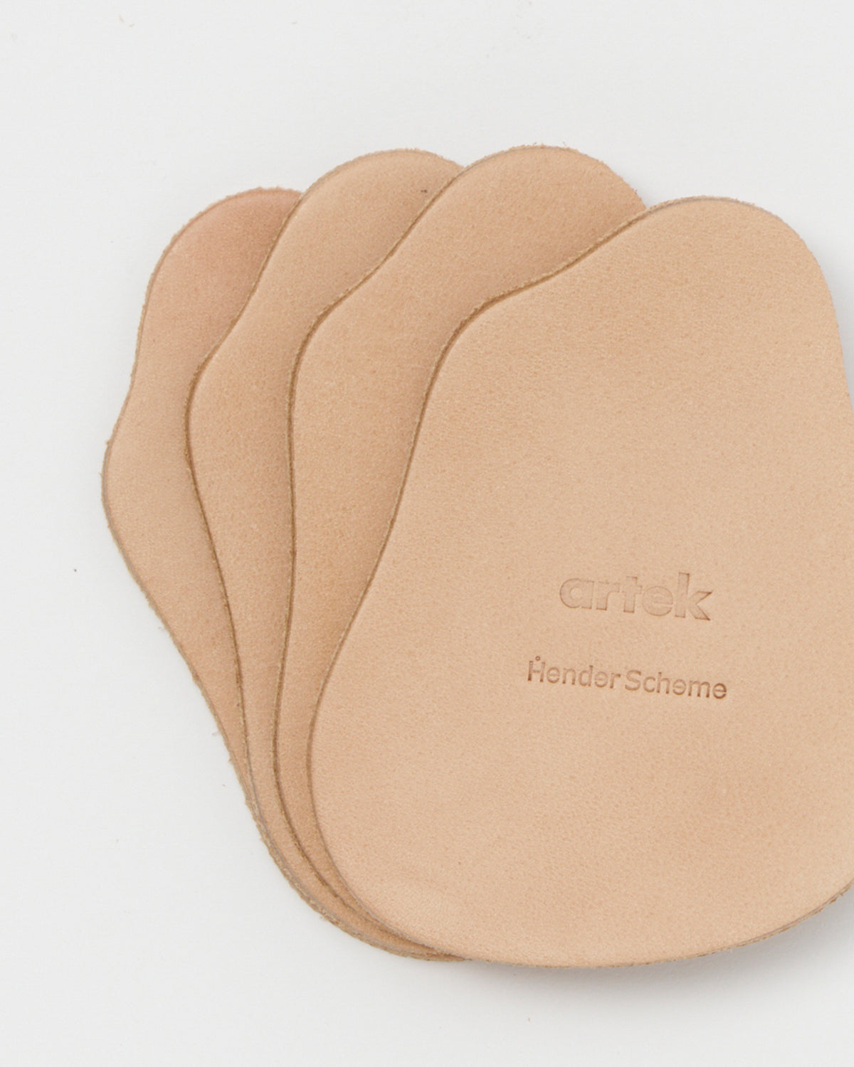 Stacked coasters by Hender Scheme and Artek on a gray background