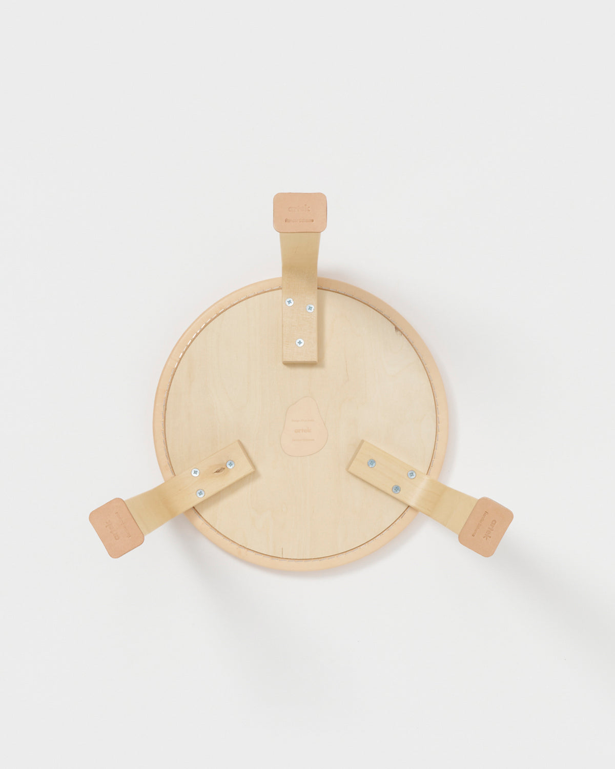 Back side of stool with shoes by Artek and Hender Scheme on a gray background