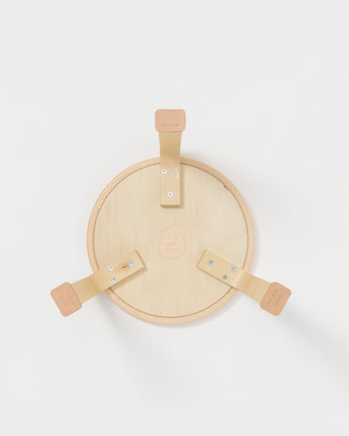 Back side of stool with shoes by Artek and Hender Scheme on a gray background