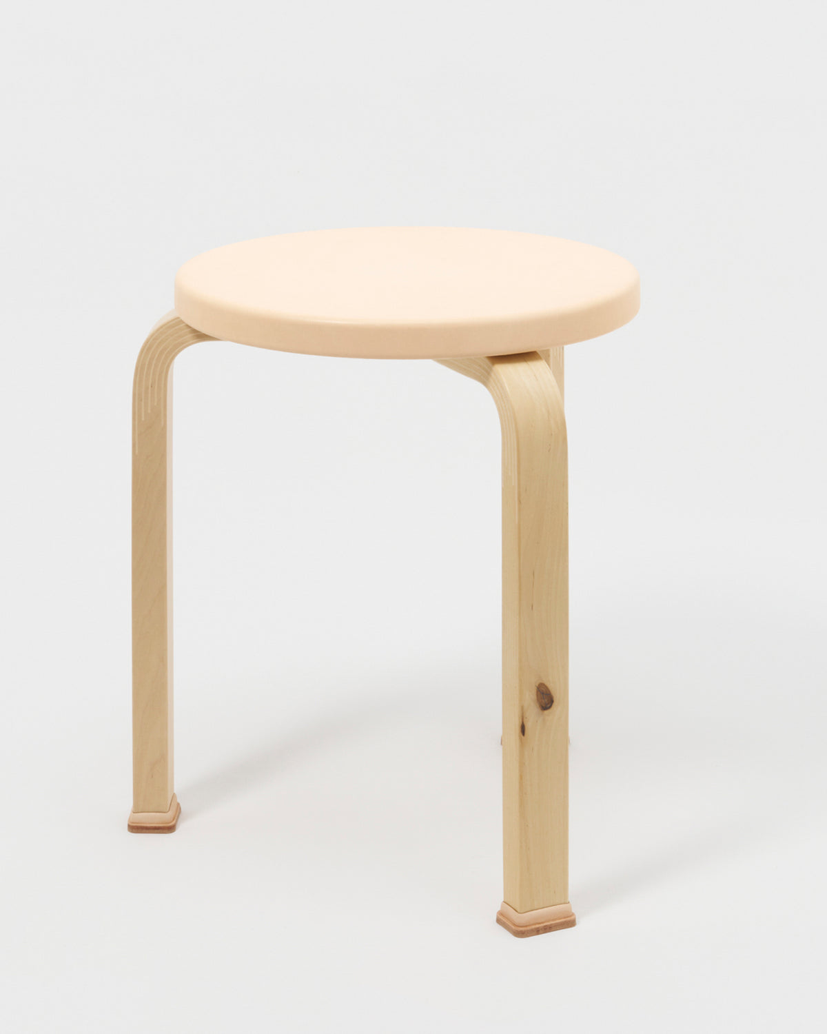 Stool with shoes by Artek and Hender Scheme on a gray background