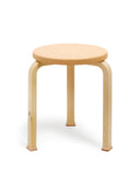 Stool with shoes by Artek and Hender Scheme on a white background