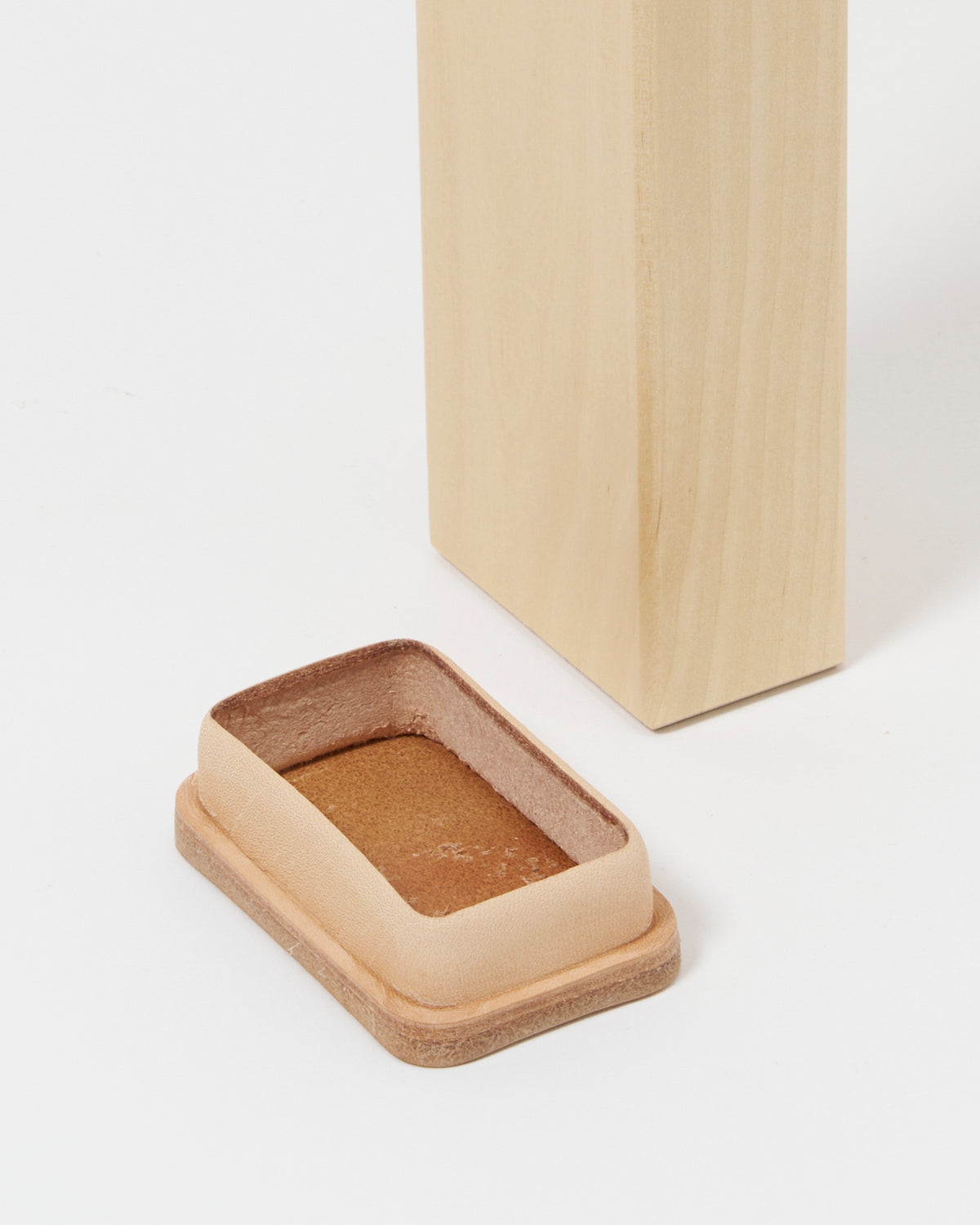 Upclose of leg of table 90c and shoe by Hender Scheme and Artek on a gray background.
