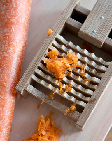 Up-close of bamboo Daikon Grater by Kohchosai Kosuga in Small size on a cutting board with carrots and grated carrots