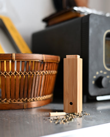 Bamboo Spice Container by Kohchosai Kosuga on a stainless steel counter with a basket and oven in the background.