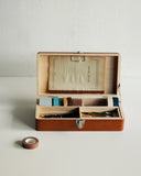 Opened Tsuga Wood Toolbox by Classiky with stationery, tape, scissors, and pens inside on a gray background
