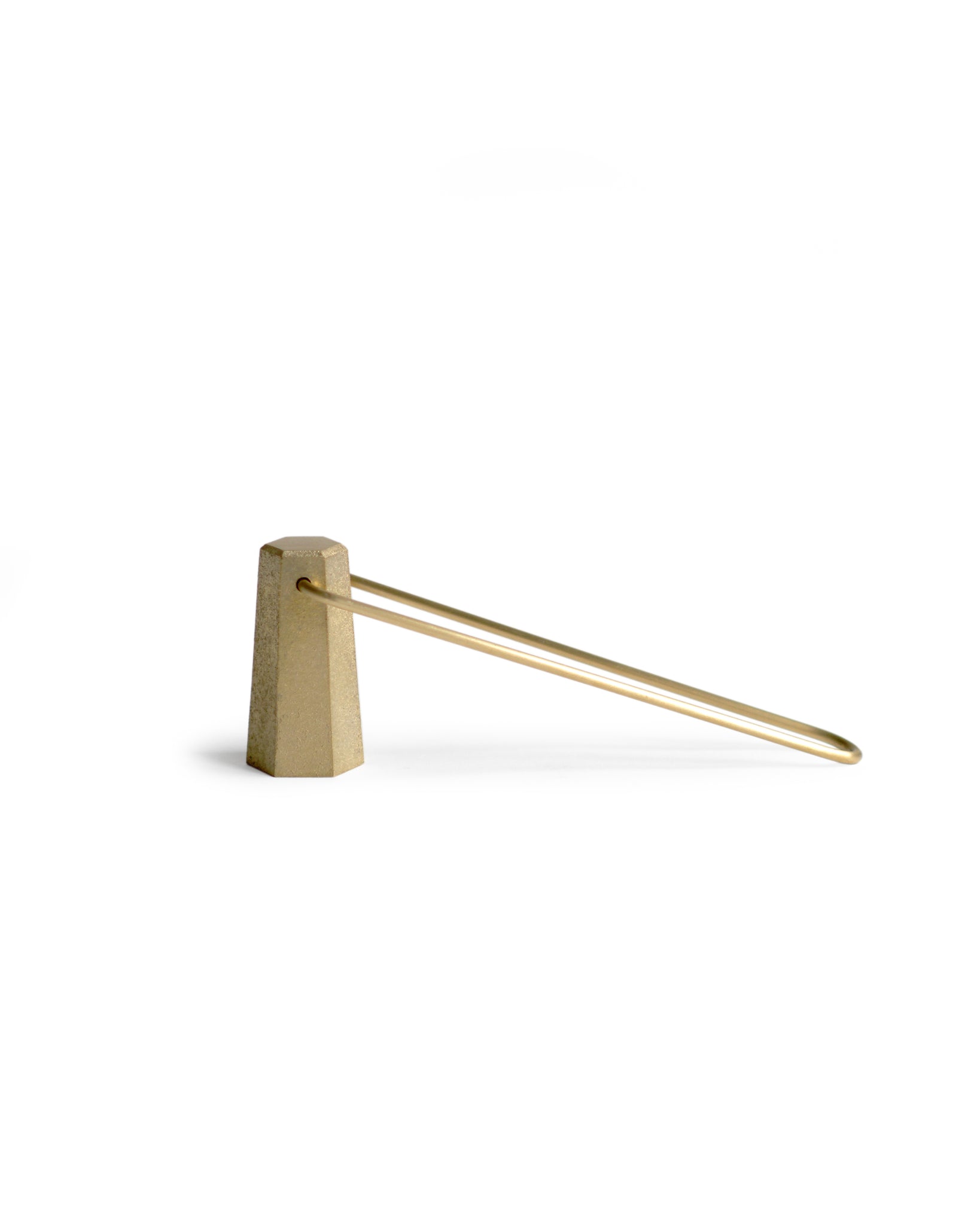 Silhouetted brass candle snuffer against white background.