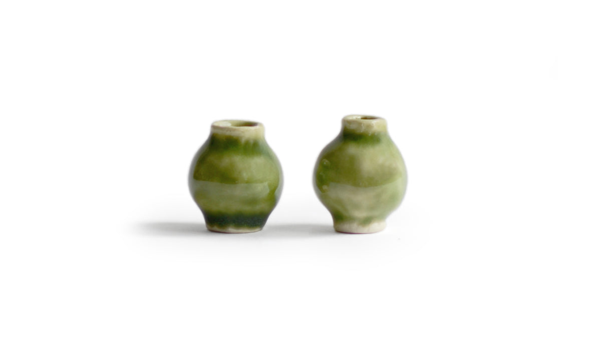 Two gloss green miniature vases from the Mini Vase Set - Duo I standing side by side against white. A Dani Sujin Studio x Nalata Nalata Collaboration