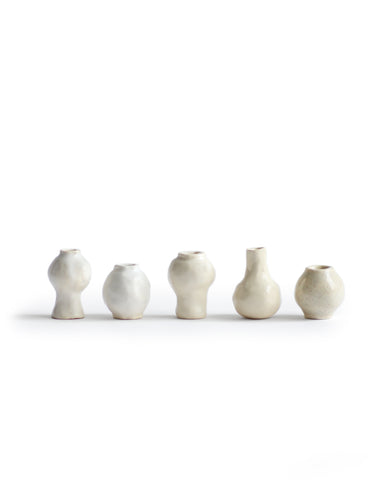 Silhouetted image of 5 varying mini white and cream glazed mini vases from the  Mini Vase Set - Quint by Dani Sujin x Nalata Nalata against white background.