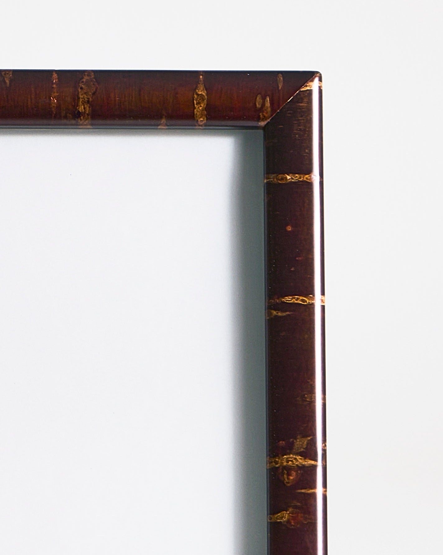 Up-close view of rectangular wooden frame by Denshiro on a gray background