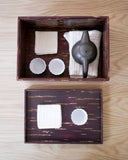 Tea set with teapot and cups in a wooden box by Denshiro on a wooden surface