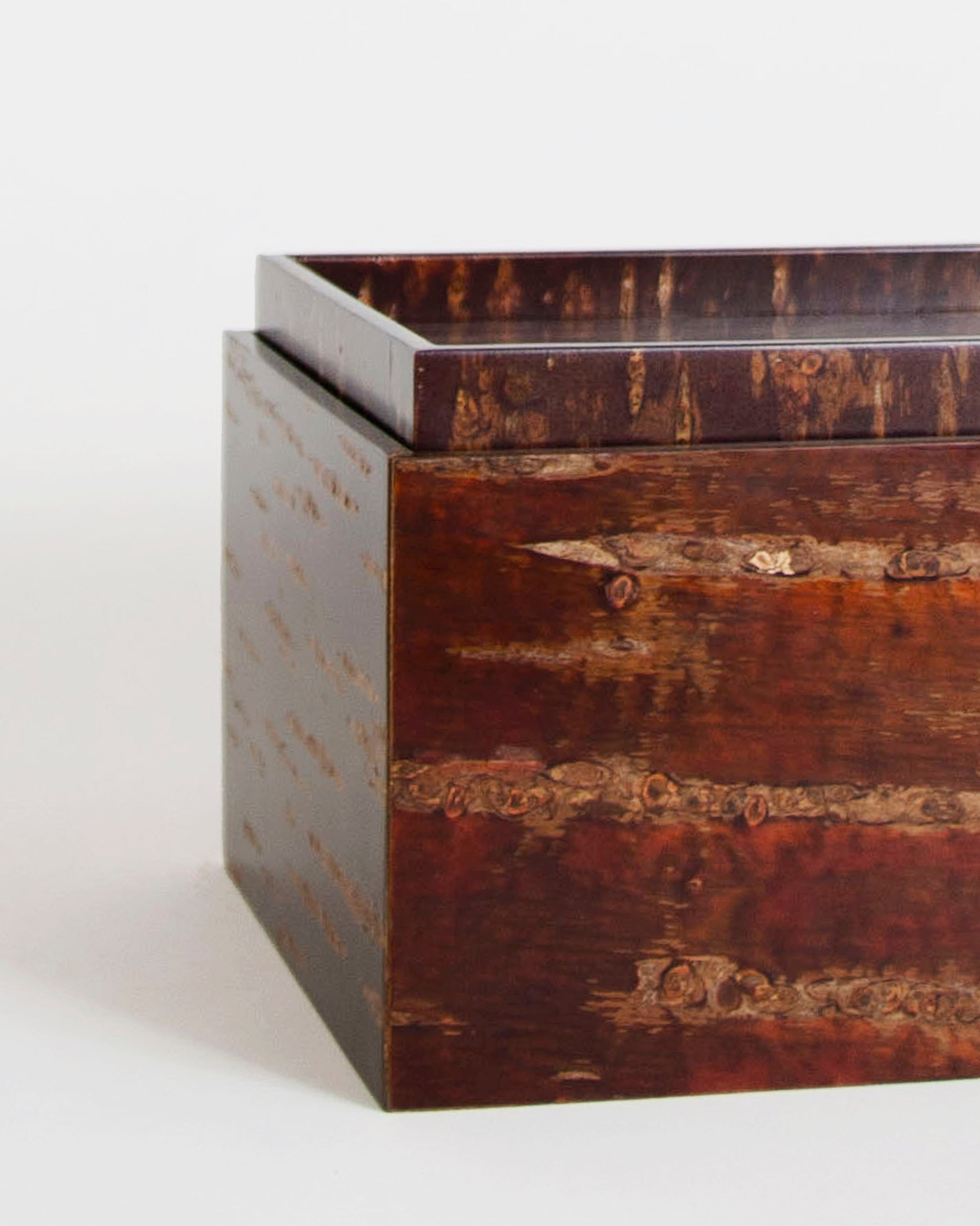 Up-close corner of wooden box by Denshiro on a gray background