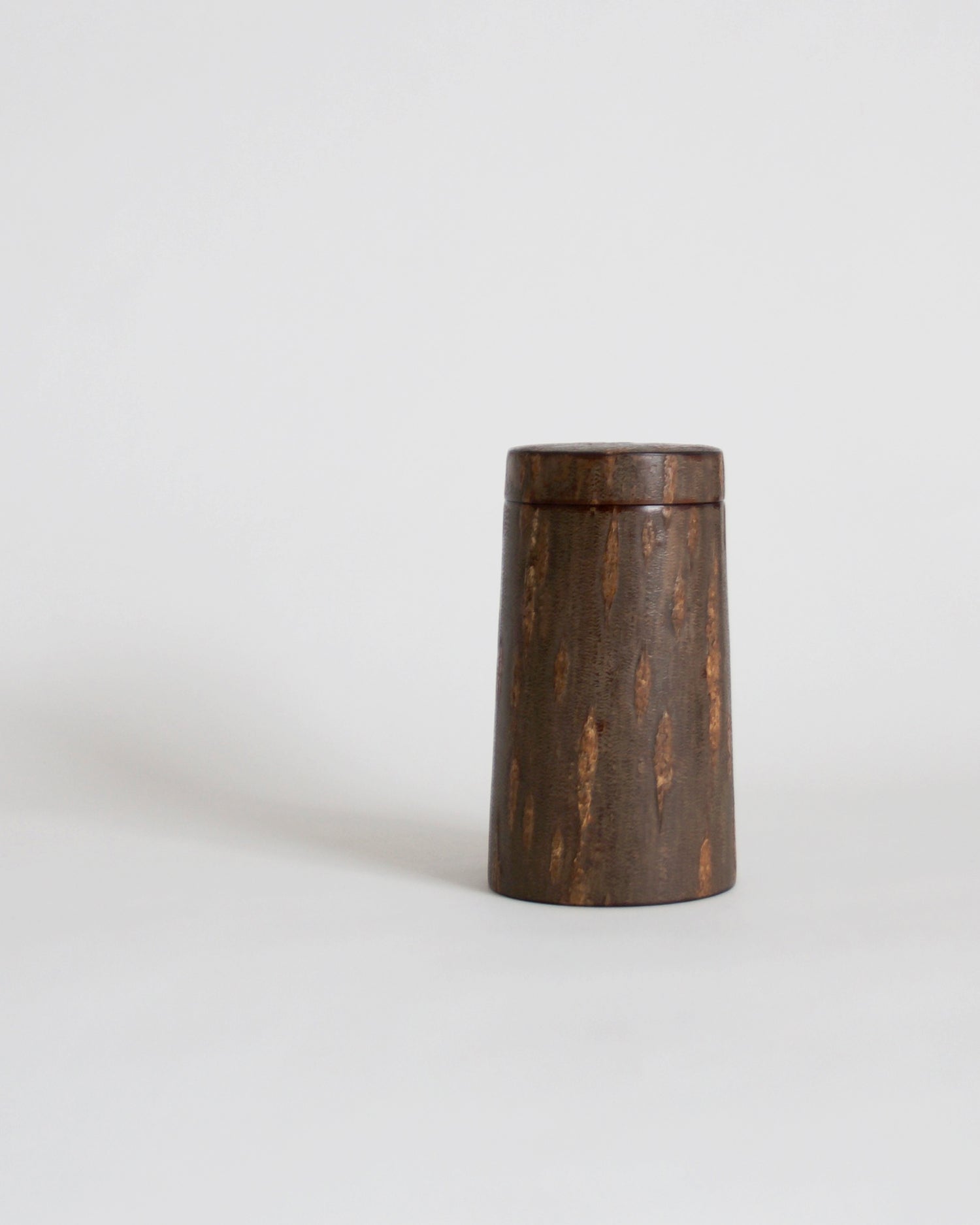 Wooden cylindrical coffee container by Denshiro on a gray background