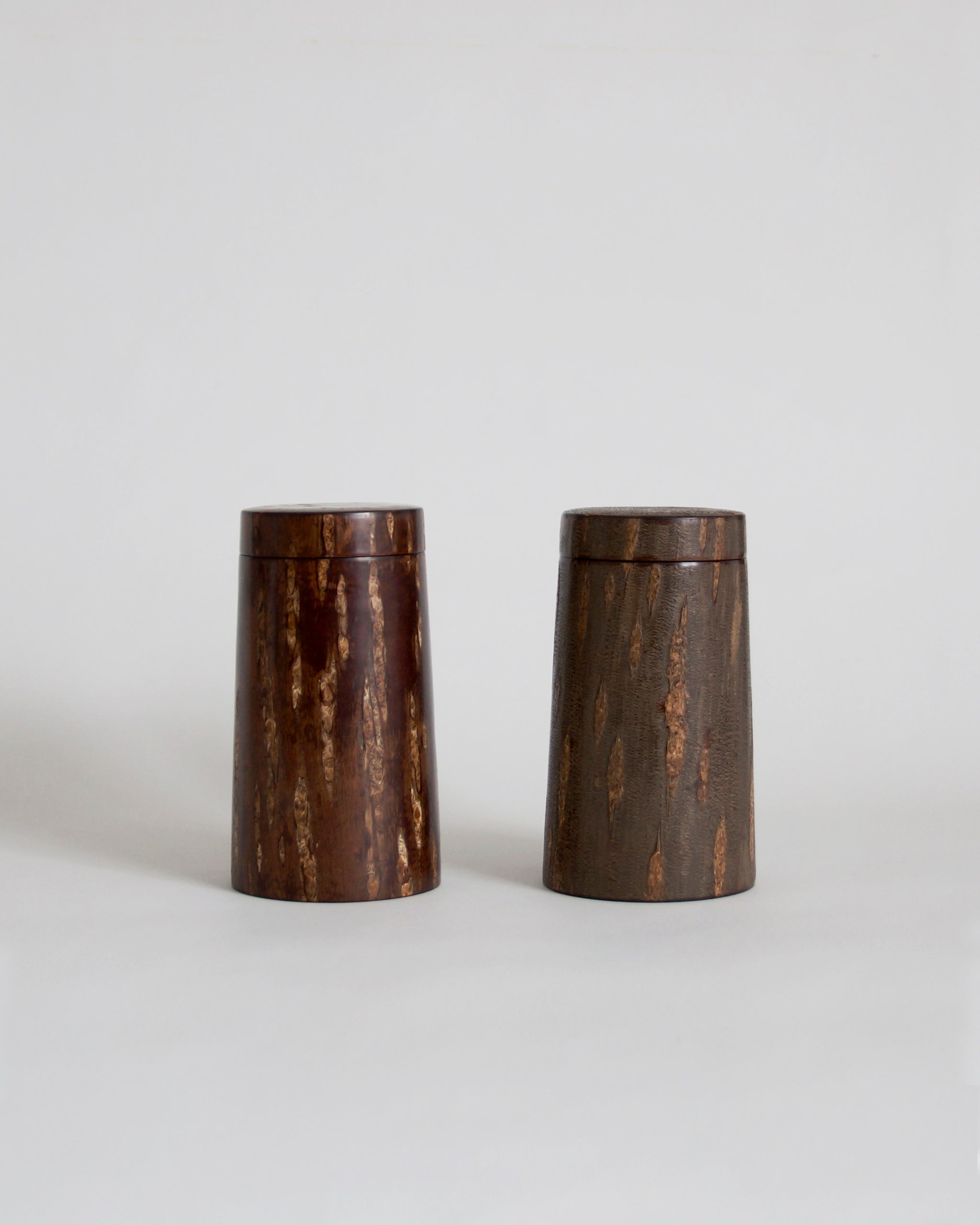 Wooden cylindrical coffee container by Denshiro on a light gray background