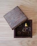 Open wooden jewelry box with jewelry on a wooden surface