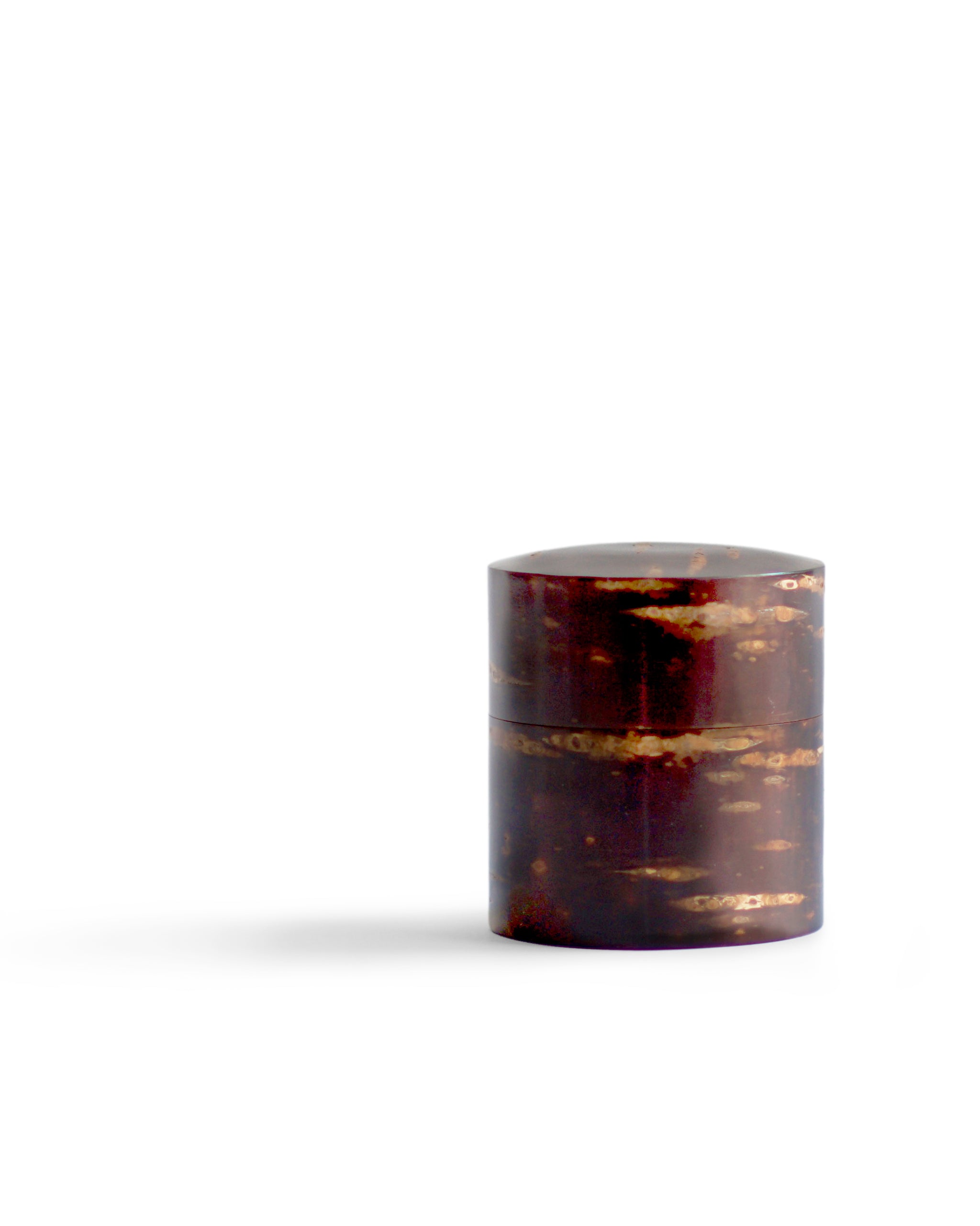 Off center silhouetted image of short Smooth Cherry Bark Tea Canister by Denshiro against white background.