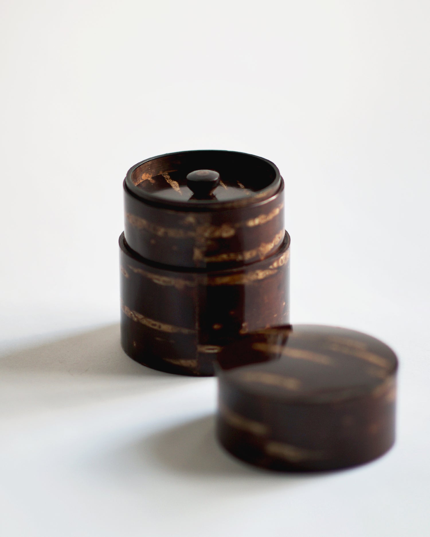 Image of open short Smooth Cherry Bark Tea Canister by Denshiro against white-gray background with lid placed infront.