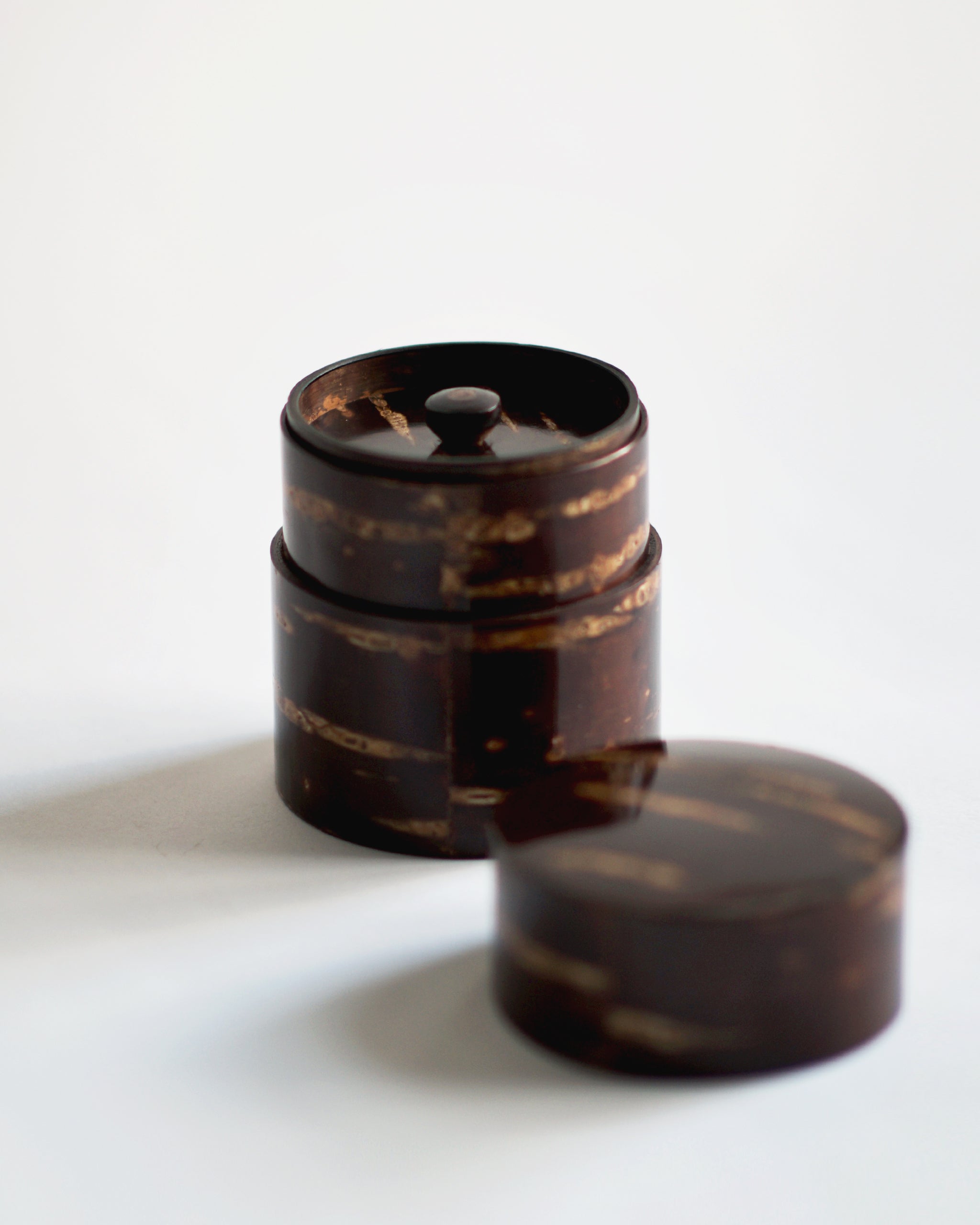 Image of open short Smooth Cherry Bark Tea Canister by Denshiro against white-gray background with lid placed infront.