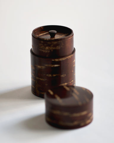 Image of open tall Smooth Cherry Bark Tea Canister by Denshiro against white-gray background with lid placed infront.