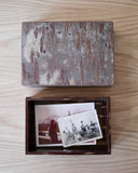 Open wooden box with vintage family photos in the interior and lid by Denshiro on a wooden surface