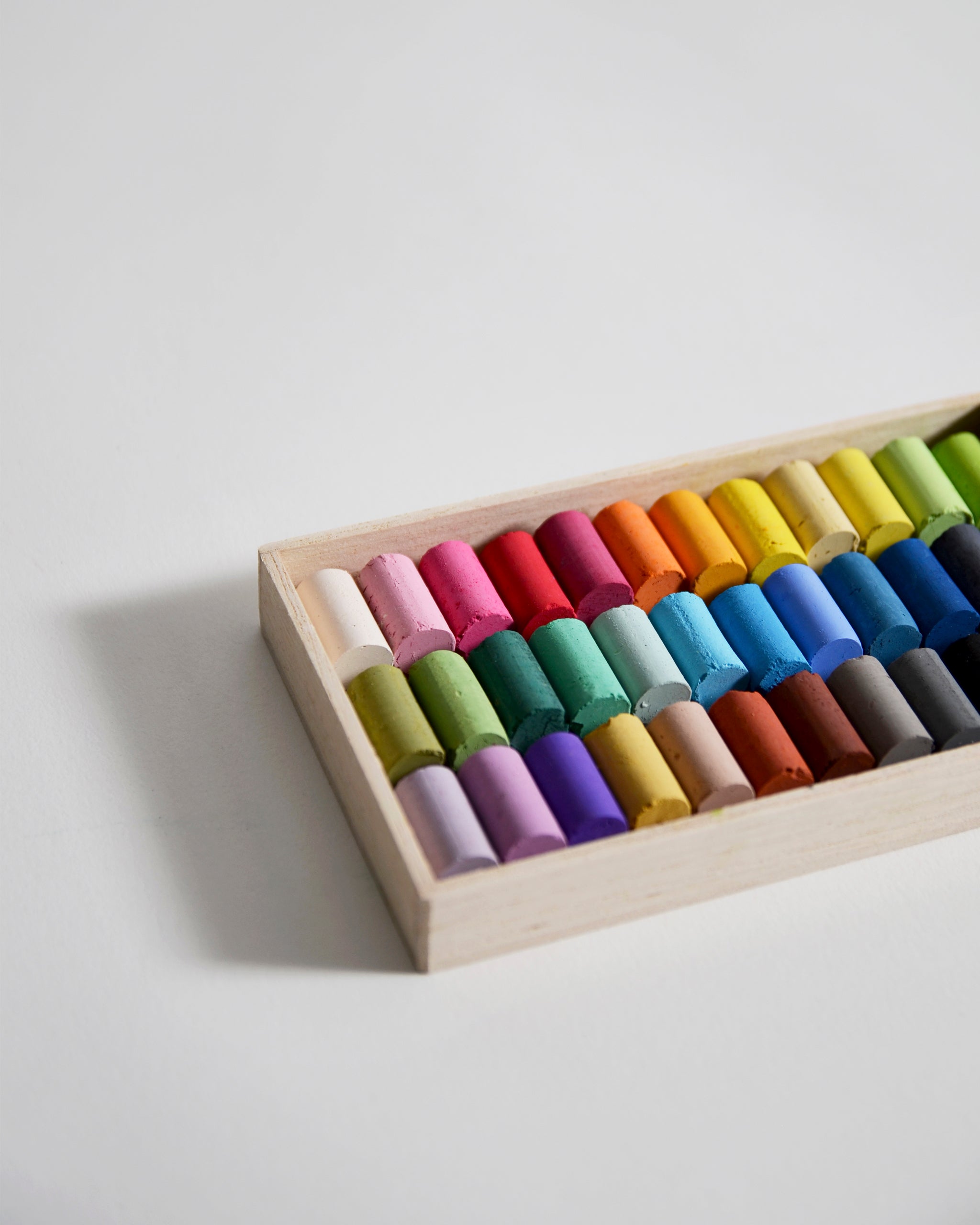 Close up of box of colorful pastels by Ohkan Kagaku Kogyosyo on a gray background