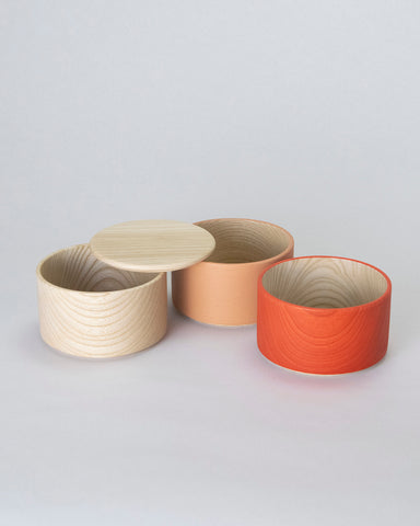 Unstacked Border Three Tiered Containers in Red, Peach, Natural on a white background.