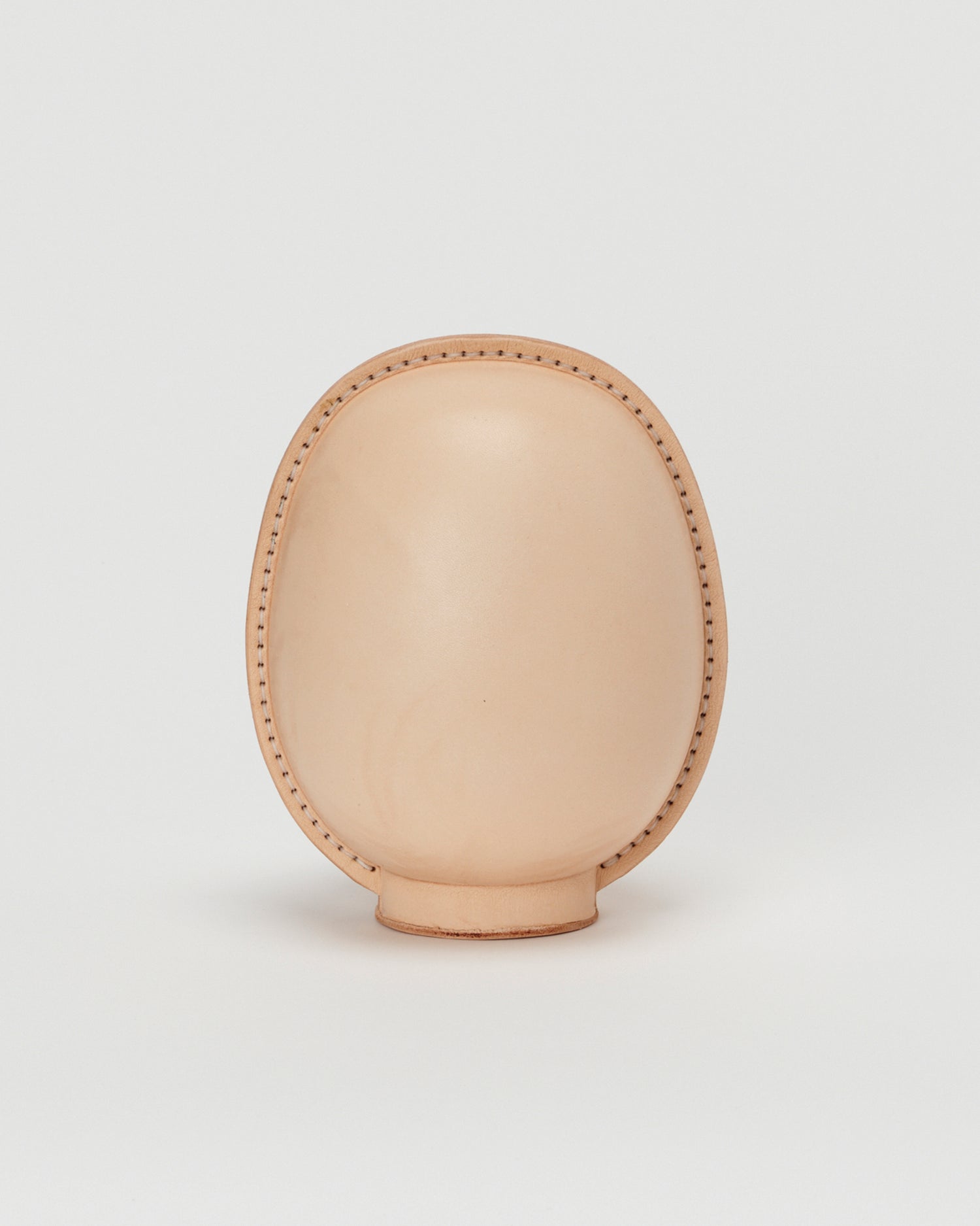Back view of large leather Daruma doll by Hender Scheme in on  a gray background