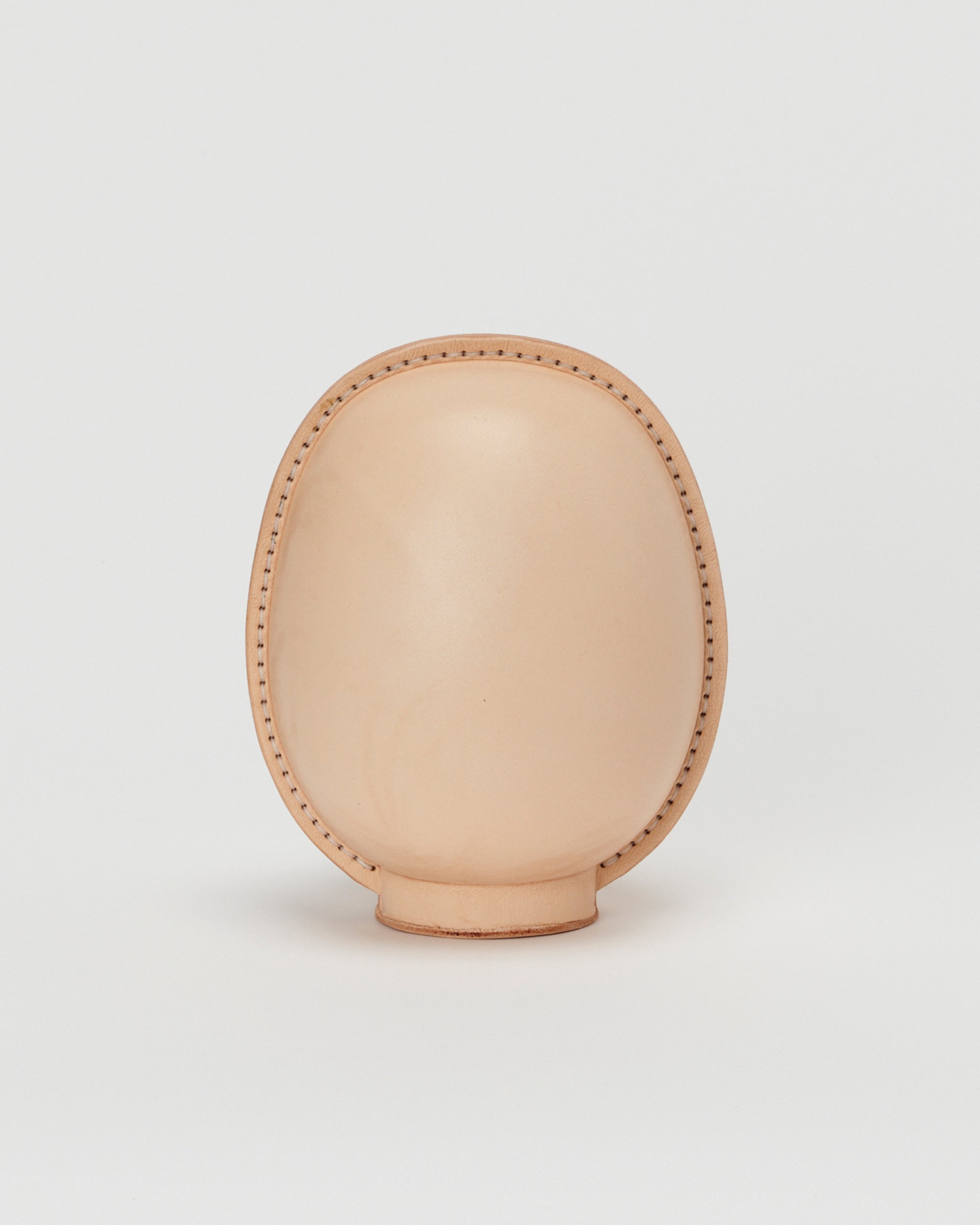 Back view of large leather Daruma doll by Hender Scheme in on  a gray background