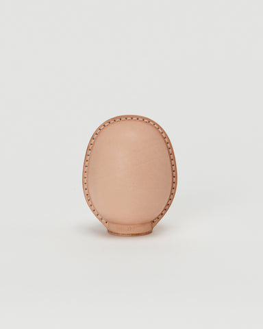 Back view of small leather Daruma doll by Hender Scheme in on  a gray background