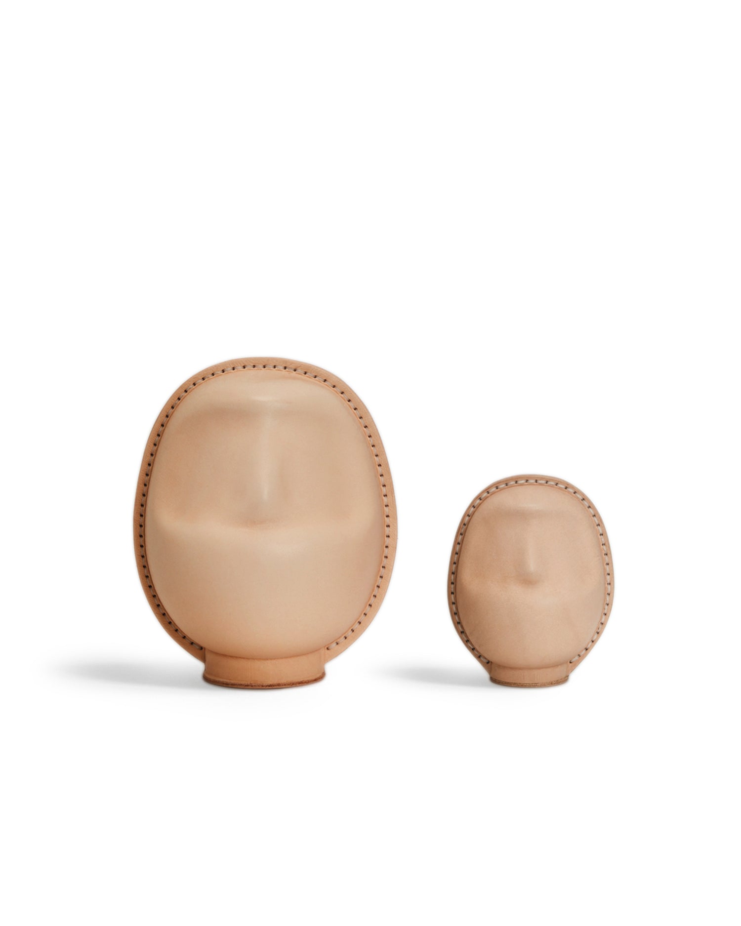 Two leather Daruma dolls by Hender Scheme in small and large on  a white background