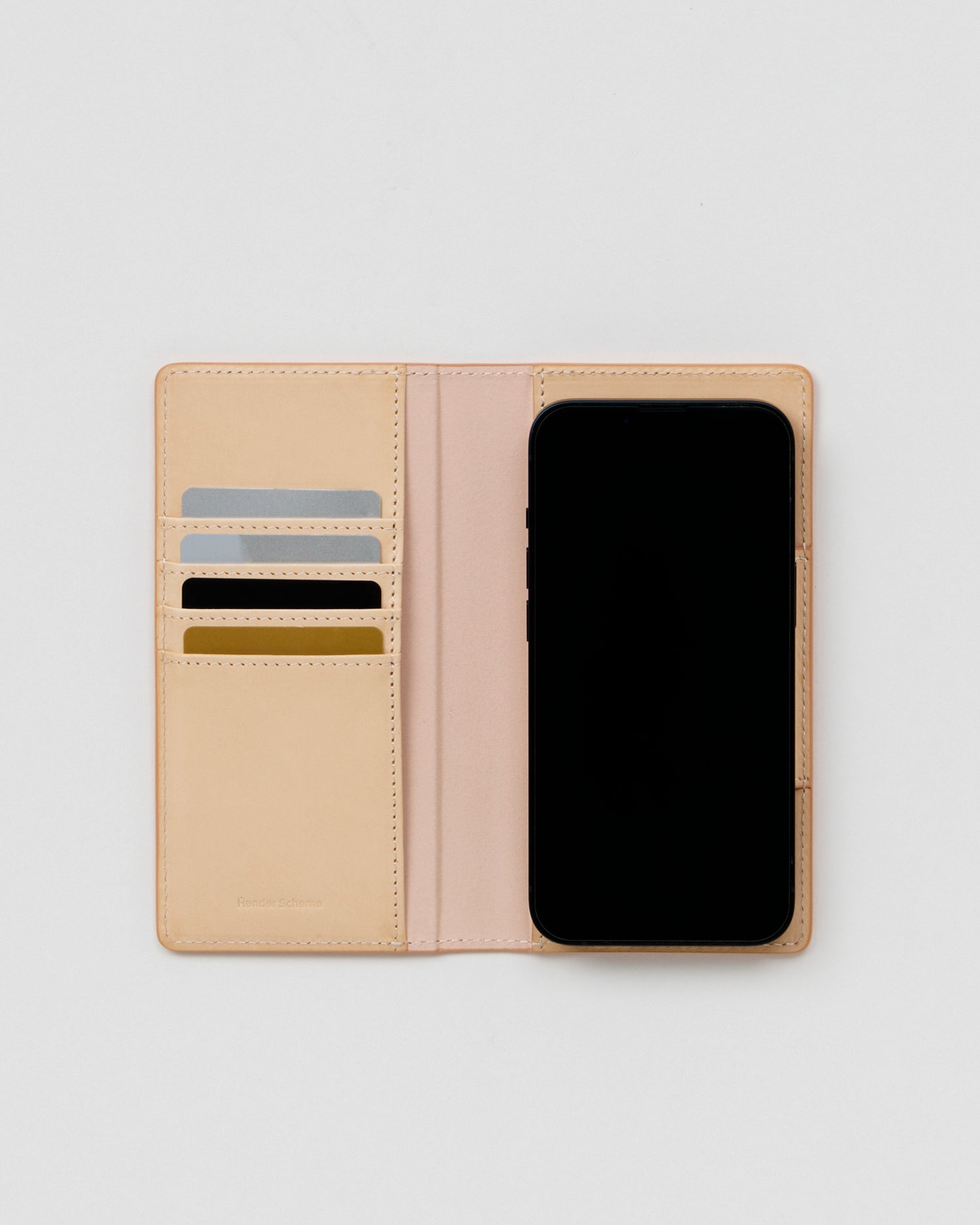 Open iPhone Case by Hender Scheme  with credit cards and phone on a gray background