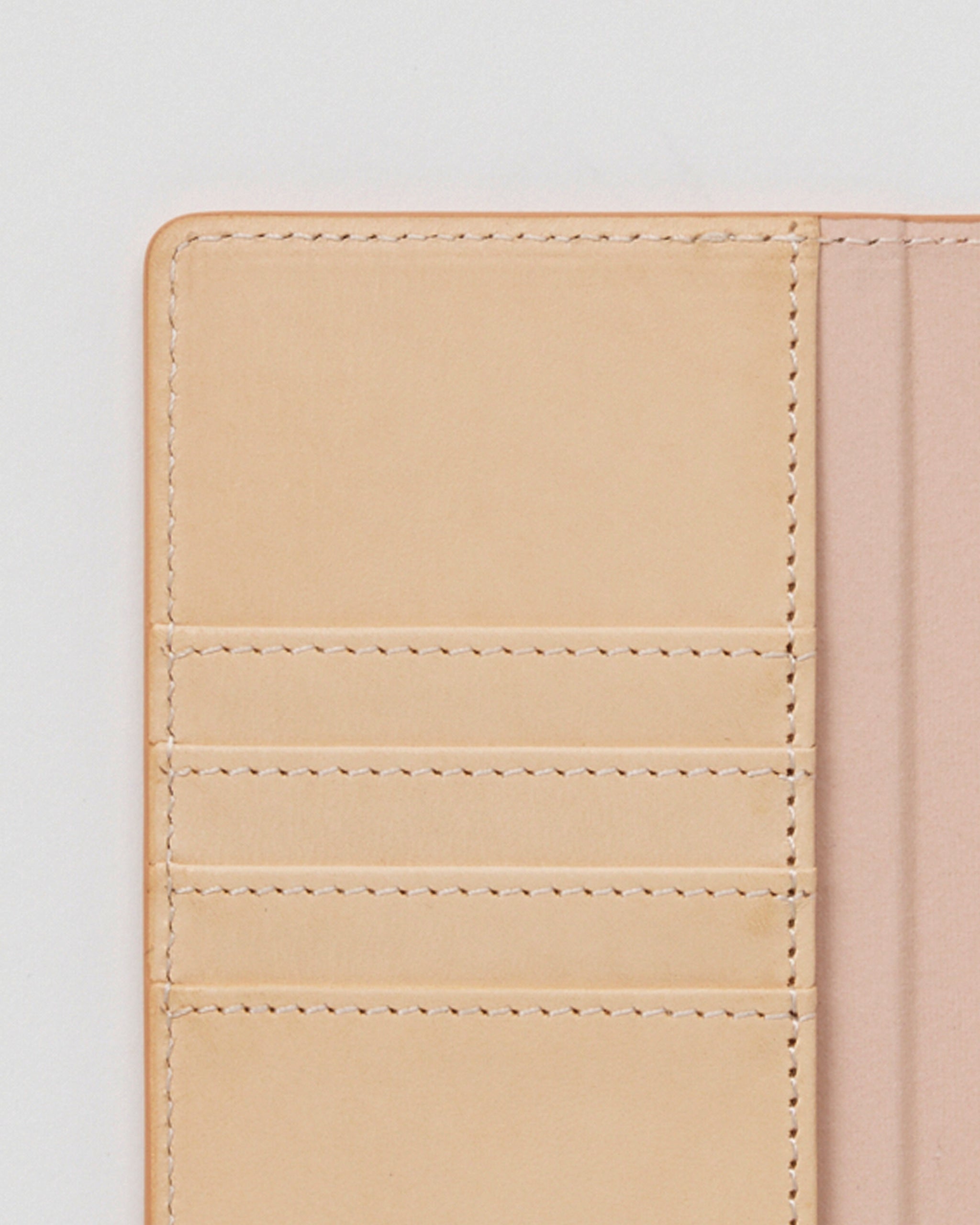 Close-up of open iPhone Case by Hender Scheme of card slots on a gray background.
