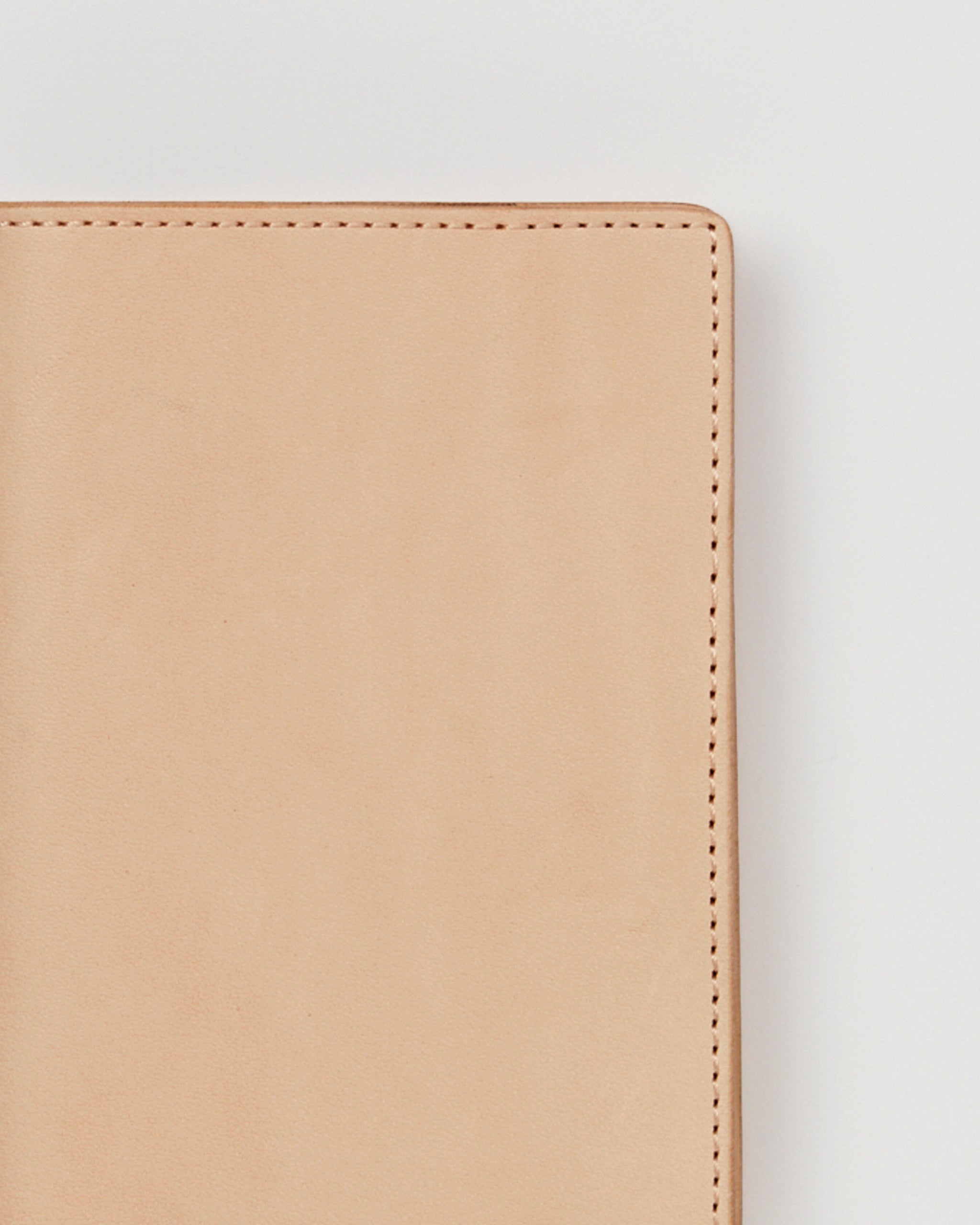 Up-close of Leather Passport Case by Hender Scheme on a gray background