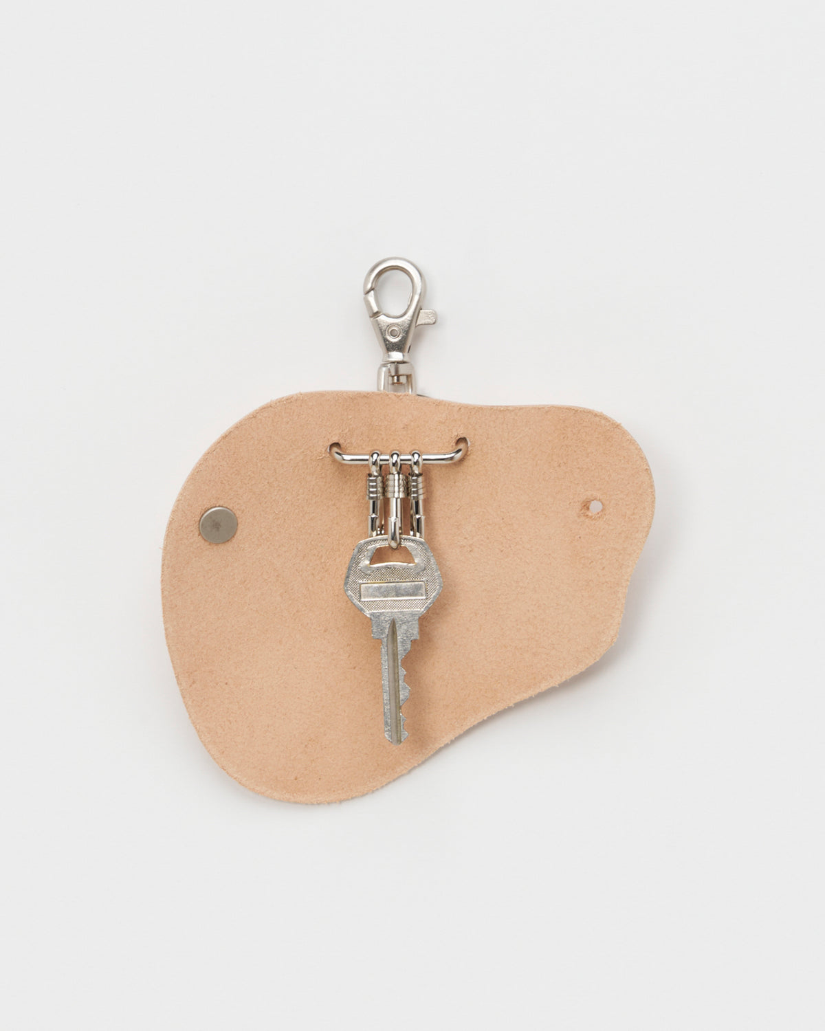 Opened Circle Cut Out Key Chain by Hender Scheme and Artek  with key on a gray background