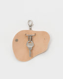 Opened Circle Cut Out Key Chain by Hender Scheme and Artek  with key on a gray background
