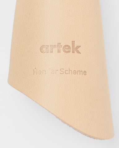 Up-close view of back of Circle Cut Out Key Chain by Hender Scheme and Artek on a gray background
