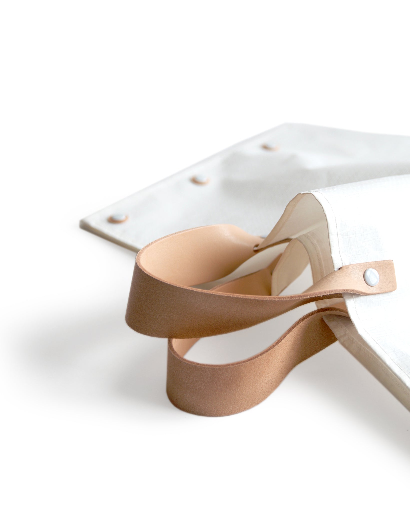 Cropped detail image of the leather handles on the hender scheme picnic bag.