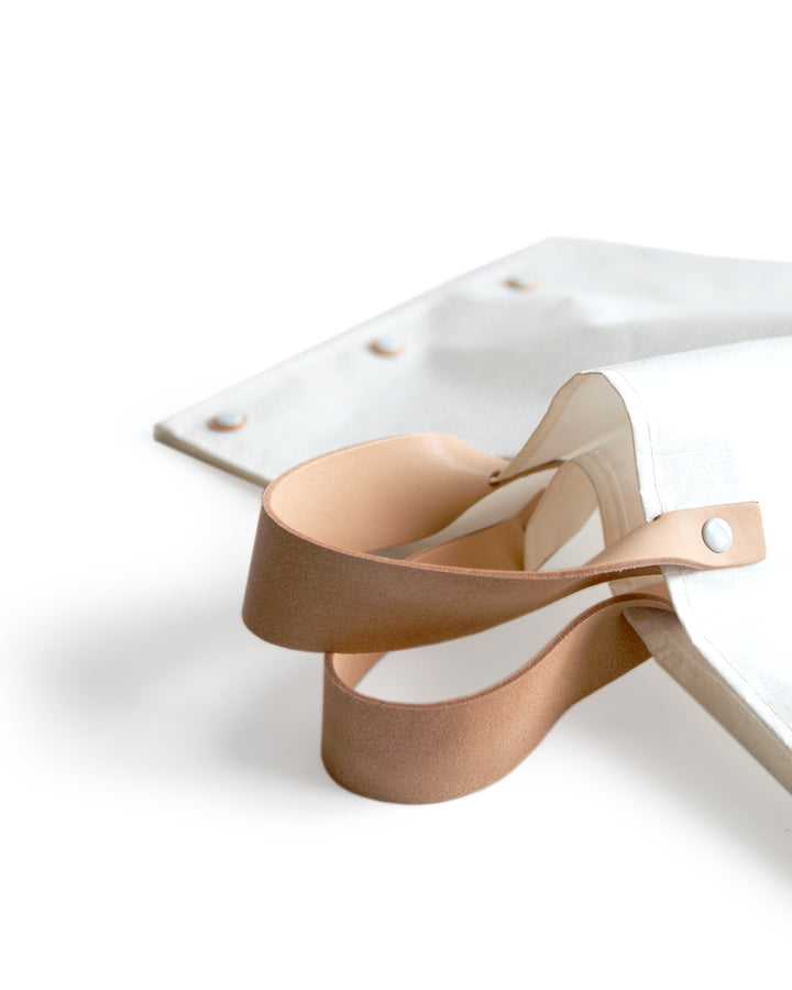 Cropped detail image of the leather handles on the hender scheme picnic bag.