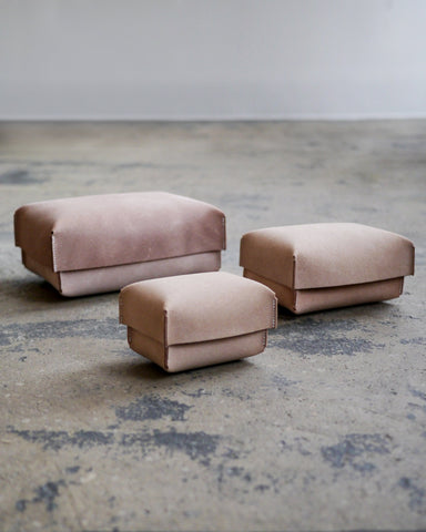 Small, medium, and large of the hender scheme two piece box are on a textured cement floor.