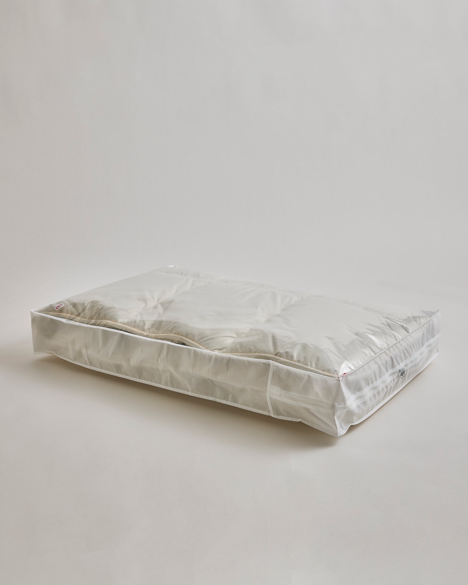 Storage bag for Camel Heavy Mattress Pad by Iwata on a gray background