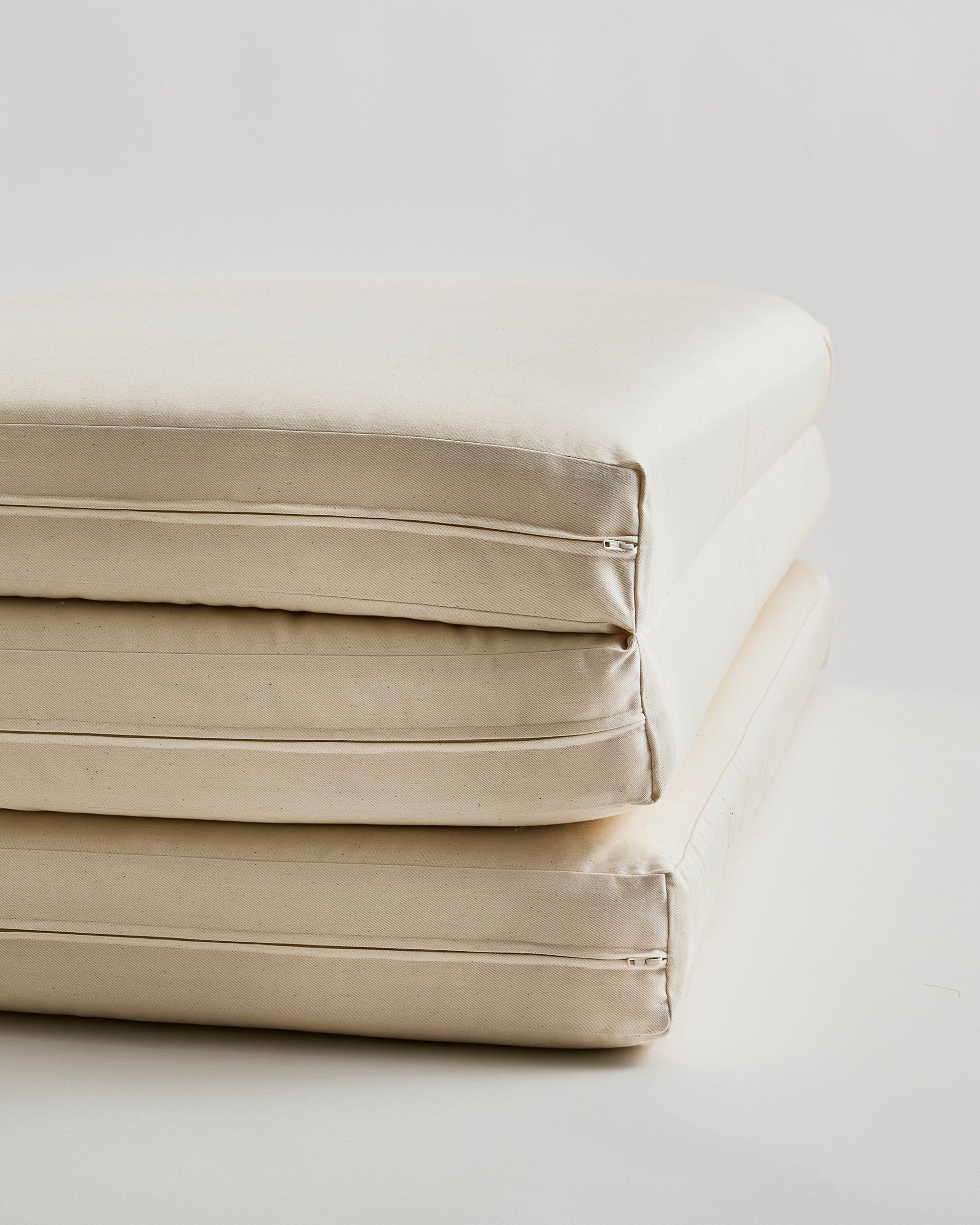 Up-close of tri-fold futon floor pad by Iwata on a light gray background