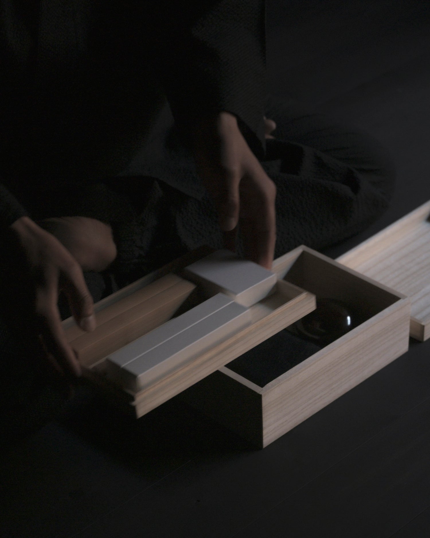 Person holding top tier of Nezen Box Set by Iwata on a Black background