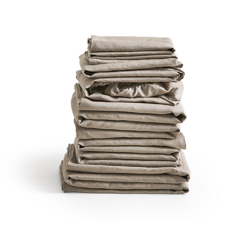 Stack of unbleached linen folded sheets by Iwata on a white background
